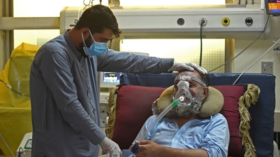 A family member comforts a Covid-19 coronavirus patient at the intensive care unit (ICU) of the Muhammed Ali Jinnah hospital in Kabul. (AFP)