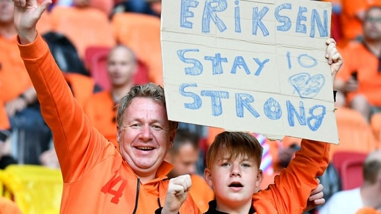 Two Netherlands fans hold a sign supporting Denmark's midfielder Christian Eriksen before the UEFA EURO 2020 Group C football match between the Netherlands and Ukraine at the Johan Cruyff Arena in Amsterdam. Eriksen was fan favourite at the stadium during his time with Dutch club Ajax Amsterdam.(AFP)