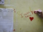 Kalpana Sinha's daughter, Deepika, 10, scribbles "I miss you papa" on a wall at their residence in New Delhi on May 9. She lost her father to Covid-19 less than a month ago and is trying to get her life back to normal, but her mother Kalpana told PTI, "nothing will ever be normal again."