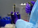 A healthcare worker holds a portable sequencer device at a genome sequencing laboratory set up at the Indira Gandhi International Airport in New Delhi.