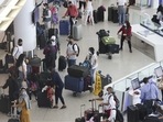 Travellers wearing protective masks line up to check-in for JetBlue Airways Corp. flights at JFK International Airport in New York, US.