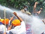Akali Dal workers face water cannon as they demand state health minister's resignation. 