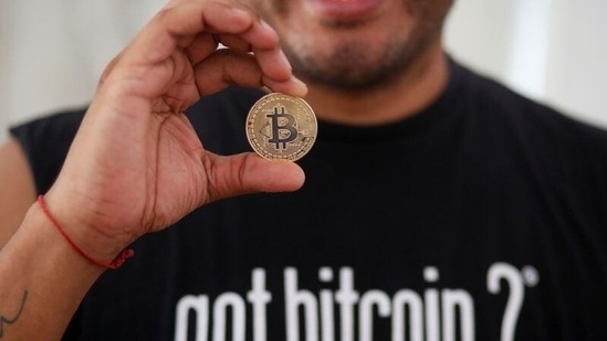 Bitcoin enthusiast Carlos Bonilla shows a physical coin at a Bitcoin beach support office at El Zonte Beach in Chiltiupan.(Reuters)