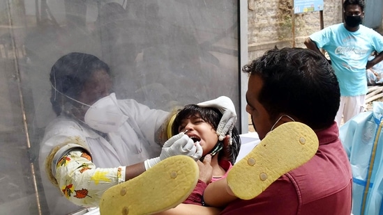 A healthcare worker testing a child for Covid-19 (ANI)