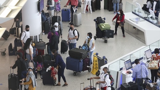 Travellers wearing protective masks line up to check-in for JetBlue Airways Corp. flights at JFK International Airport in New York, US. (Bloomberg) Travellers wearing protective masks line up to check-in for JetBlue Airways Corp. flights at JFK International Airport in New York, US. (Bloomberg)