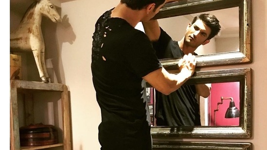 Sushant Singh Rajput looking at his reflection in the mirror in his living room. (Instagram)