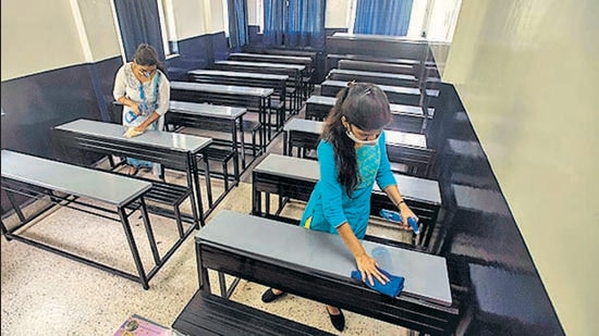 Staff members of Takalkar coaching class sanitise a classroom at Bibwewadi in Pune on Monday. (PRATHAM GOKHALE/HT) Staff members of Takalkar coaching class sanitise a classroom at Bibwewadi in Pune on Monday. (PRATHAM GOKHALE/HT)