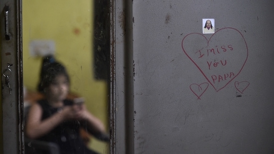 Deepika reflected in a mirror, while a photo of her father is seen on an almirah, in New Delhi on May 9. In an attempt to provide help to non-earning single parents like Kalpana and Madhu, and caretakers like Asif, Bachpan Bachao Andolan (BBA), an NGO led by Nobel laureate Kailash Satyarthi has been identifying children rendered orphans during the pandemic for almost a year now.(Arun Sharma / PTI)