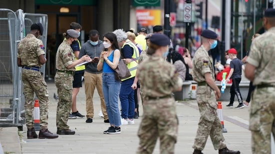 Members of the armed forces speak to people, outside a mobile Covid-19 vaccination centre, in Bolton, England.(AP File Photo)
