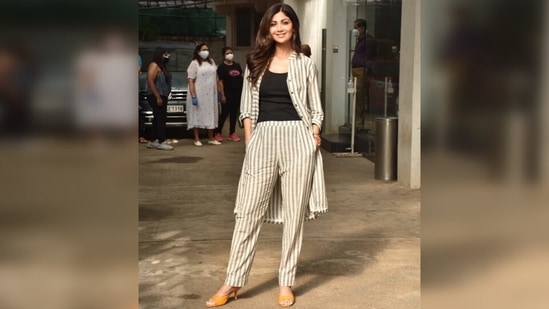 Shilpa was snapped in a white striped co-ord set and looked her glamorous best. She wore a long button-up shirt that had grey pinstripe print with matching high waist pants. (Varinder Chawla)