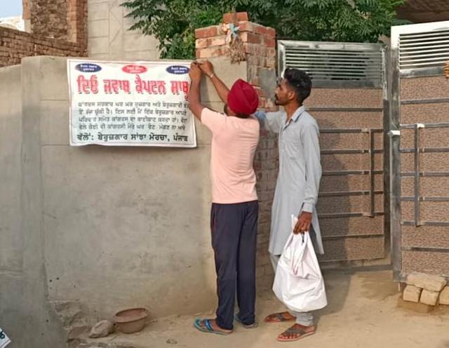 Two youths installing a banner outside their house to question the Punjab government on the status of their jobs and unemployment allowances. (HT Photo) Two youths installing a banner outside their house to question the Punjab government on the status of their jobs and unemployment allowances. (HT Photo)