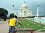 A worker spray disinfects at Taj Mahal premises in Agra on Monday, a day before its reopening.(ANI Photo) A worker spray disinfects at Taj Mahal premises in Agra on Monday, a day before its reopening.(ANI Photo)
