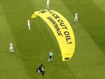 The German players look on as a Greenpeace paraglider lands in the stadium prior to the start of the match. (AP) The German players look on as a Greenpeace paraglider lands in the stadium prior to the start of the match. (AP)