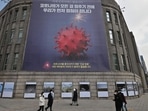 Pedestrians walk past a poster depicting the coronavirus, at the City Hall in Seoul, South Korea.(AFP for representation) Pedestrians walk past a poster depicting the coronavirus, at the City Hall in Seoul, South Korea.(AFP for representation)