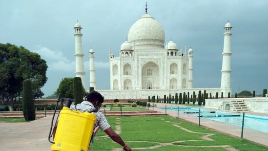 A worker spray disinfects at Taj Mahal premises in Agra on Monday, a day before its reopening.(ANI Photo)