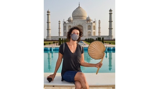A tourist poses for a portrait in front of the Taj Mahal, in Agra, on June 16. "Masks will be mandatory for tourists. Thermal screening of tourists would be done at the gates and they would be sanitised before entering the monument premises," Superintending Archaeologist, ASI, Agra Circle, Vasant Kumar Swarnakar told HT.(PTI)