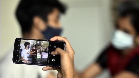 A woman take photo of her brother who get his first Jab of Covid Vaccination at Poly Clinic in Sector 31, in Gurugram. (HT photo) A woman take photo of her brother who get his first Jab of Covid Vaccination at Poly Clinic in Sector 31, in Gurugram. (HT photo)