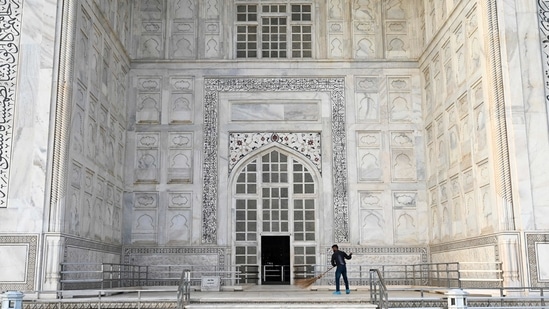 A worker sweeps the floor in front of an entrance to the Taj Mahal, in Agra on June 16. In an order on April 15, the ASI had shut monuments till May 31 due to a surge in Covid-19 cases in the second wave.(Money Sharma / AFP)