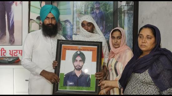 Gurbinder Singh’s family with his photo at their home in Tolowal village near Sunam in Sangrur. (HT Photo)