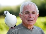 Xavier Bouget, 80-year-old Frenchman, who built a strong relation with a wild pigeon called "Blanchon", looks on as he stands in his garden with the pigeon on his shoulder, in the village of Gommenec'h in Brittany, France, June 14, 2021. Picture taken June 14, 2021. REUTERS/Stephane Mahe