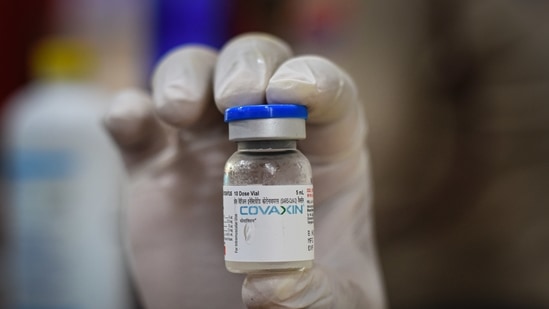 A health worker holding up a vial of Covaxin, a Covid-19 vaccine at a school being used as a vaccination site in Kingsway Camp, New Delhi, India, (Sanchit Khanna / HT PHOTO)