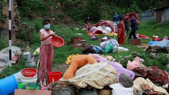 Locals gather their belongings as they move towards higher ground from the flood-affected area in Sindhupalchok, on June 16. Nearly 200 families residing along the Melamchi River Corridor have been displaced from their homes and have been taking shelter in a local school since June 15 evening, ANI reported.(Navesh Chitrakar / REUTERS)
