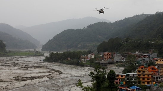 A Nepal Army helicopter flies above the swollen Melamchi river during a rescue mission in Sindhupalchok, on June 16. The Nepal Army along with Armed Police Force and the Nepal Police has been conducting a rescue and search operation in the flood-ravaged area, which continues to be submerged under a thick layer of mud and high flowing water.(Navesh Chitrakar / REUTERS)