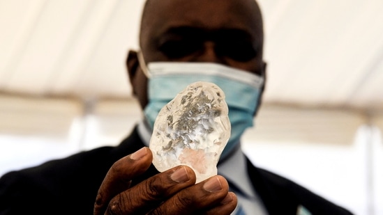 Botswana President Mokgweetsi Masisi holds a gem diamond in Gaborone, Botswana, on June 16, 2021.(AFP) Botswana President Mokgweetsi Masisi holds a gem diamond in Gaborone, Botswana, on June 16, 2021.(AFP)