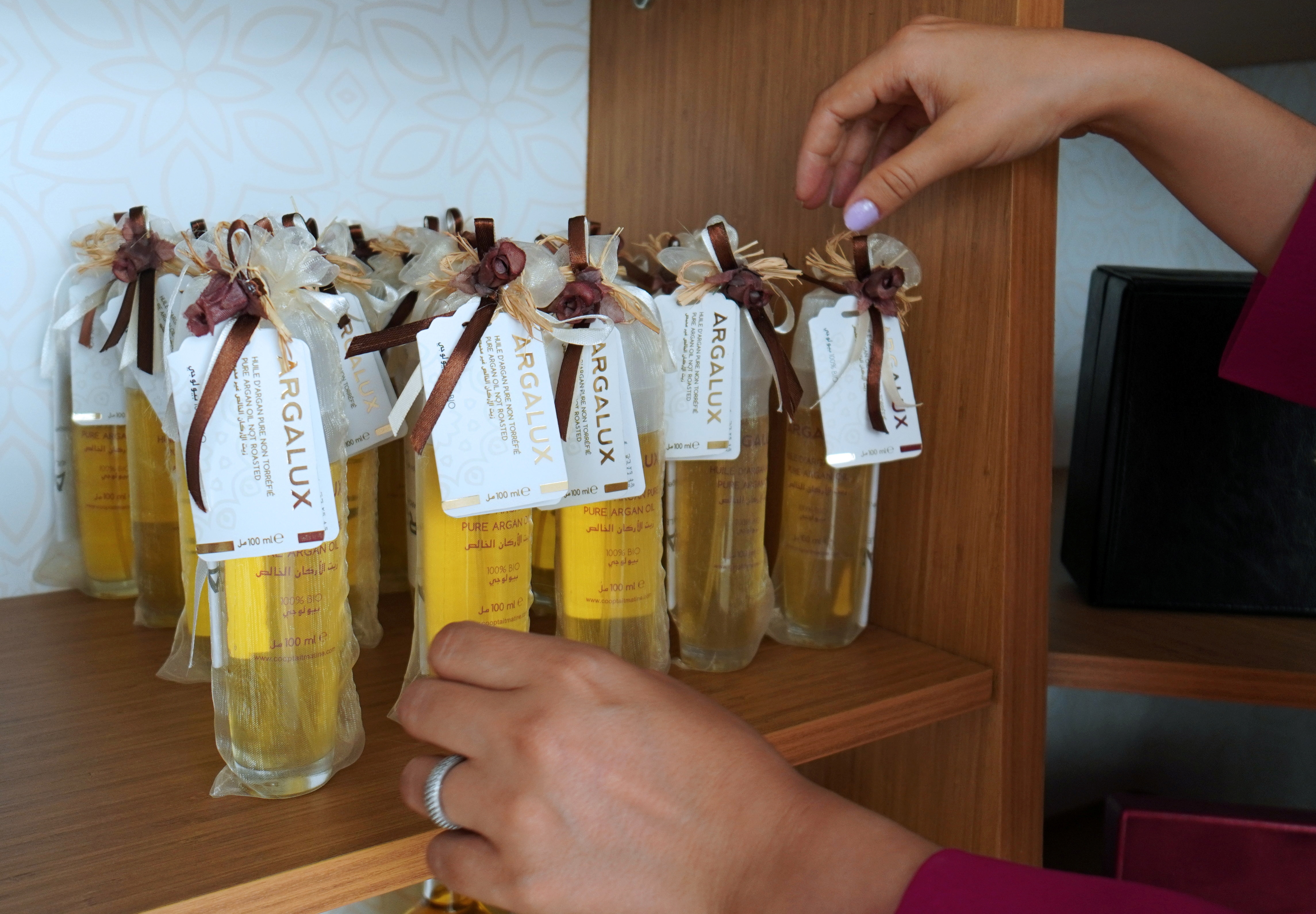 A woman arranges argan oil bottles for sale inside the showroom of Women's Agricultural Cooperative Taitmatine, in Agadir, Morocco June 8, 2021. (REUTERS)