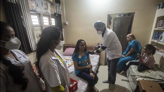 A beneficiary (centre) gets her Covid-19 vaccine jab at her home during the door-to-door vaccination drive at Shaniwar Peth in Pune. (HT PHOTO) A beneficiary (centre) gets her Covid-19 vaccine jab at her home during the door-to-door vaccination drive at Shaniwar Peth in Pune. (HT PHOTO)