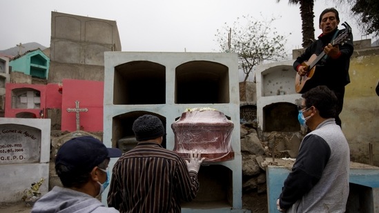 A relative of Marco Antonio Carillo, 48, who died of Covid-19 according to his family, plays the guitar during his burial at the "Martires 19 de Julio" cemetery on June 1 in Lima, Peru. Deaths from the coronavirus have exceeded 4 million as on June 17, Reuters reported citing a tally by the news agency.(Angela Ponce / Getty Images)