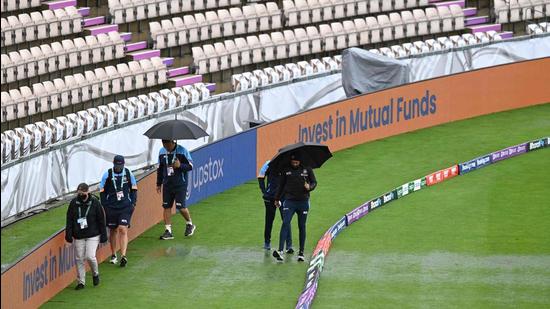 Staff of the India team walk around the outfield on the rain-affected first day of the ICC World Test Championship Final against New Zealand at the Ageas Bowl in Southampton. (AFP)
