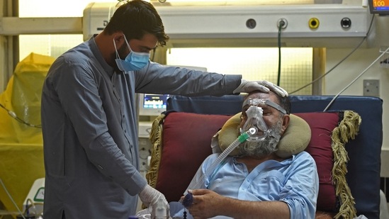 A family member comforts a Covid-19 coronavirus patient at the intensive care unit (ICU) of the Muhammed Ali Jinnah hospital in Kabul, Afghanistan on June 8. It took over a year for the COVID-19 death toll to hit 2 million, while the next 2 million were recorded in just 166 days, according to a Reuters analysis.(Wakil Kohsar / AFP)