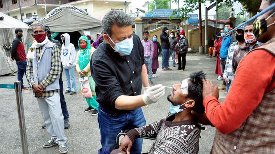 A health worker collects a nasal sample from a man for Covid-19 testing in Kullu of Himachal. (ANI)
