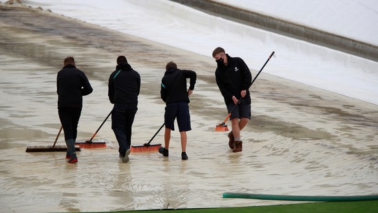 Groundsmen clear water of the covers protecting the pitch after the rain-delayed start of the first day of the World Test Championship final cricket match between New Zealand and India, at the Ageas Bowl in Southampton.(AP) Groundsmen clear water of the covers protecting the pitch after the rain-delayed start of the first day of the World Test Championship final cricket match between New Zealand and India, at the Ageas Bowl in Southampton.(AP)