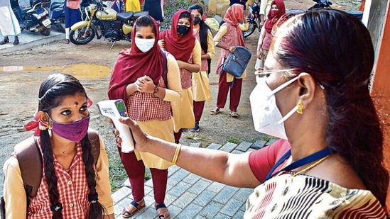 Students undergo temperature checks as schools reopen in Palakkad after months, in January. PTI Students undergo temperature checks as schools reopen in Palakkad after months, in January. PTI