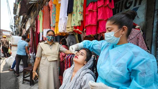 File photo: A health worker collects a nasal sample from a woman for Covid-19 testing at a market in Jammu. (PTI) File photo: A health worker collects a nasal sample from a woman for Covid-19 testing at a market in Jammu. (PTI)