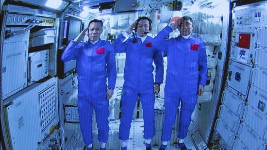 Chinese astronauts salute after successfully entering the Tianhe space station module on Thursday. (AP) Chinese astronauts salute after successfully entering the Tianhe space station module on Thursday. (AP)