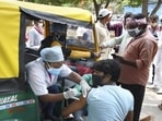 Health workers administer the Covid-19 vaccine to auto-rickshaw drivers outside the railway station in Ranchi, Jharkhand.