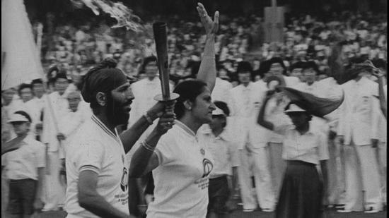 Star Indian athletes Milkha Singh (left) and Kanwaljit Sandhu stride proudly round the track at Jawaharlal Nehru Stadium bearing aloft the torch of Asian Games 82. (HT File)