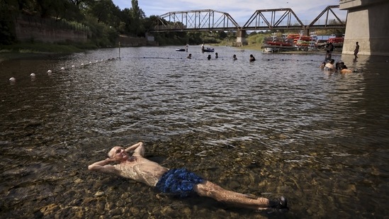 Gerry Huddleston cools off in the very shallow water of the Russian River on June 16 at the Veterans Memorial Beach in Healdsburg, California. A growing number of scientific studies are concluding that heat waves in some cases can be directly attributed to climate change, Kristie L. Ebi, a professor at the Center for Health and the Global Environment at the University of Washington told AP. That means the US West and the rest of the world can expect more extreme heat waves in the future unless officials move to cut down on greenhouse gas emissions.