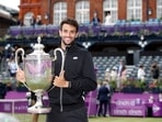 Italy's Matteo Berrettini poses as he celebrates winning the final match against Britain's Cameron Norrie with the trophy.