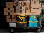 An Amazon delivery worker pulls a delivery cart full of packages during its annual Prime Day promotion in New York City, US. 