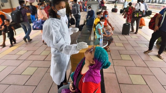 A BMC health worker is collect swab samples for Covid teat of the passengers at Dadar station in Mumbai.(Satish Bate/HT Photo) A BMC health worker is collect swab samples for Covid teat of the passengers at Dadar station in Mumbai.(Satish Bate/HT Photo)