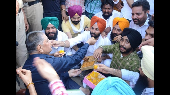 Congress MLA Rakesh Pandey offers sweets to Youth Akali Dal workers protesting outside his house in Ludhiana on Monday. Congress MLA Rakesh Pandey offers sweets to Youth Akali Dal workers protesting outside his house in Ludhiana on Monday.