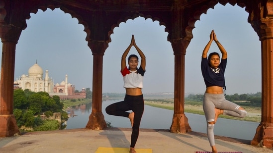 Two girls performed yoga near the Taj Mahal ahead of International Yoga Day on Sunday. (PTI) Two girls performed yoga near the Taj Mahal ahead of International Yoga Day on Sunday. (PTI)