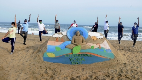 Ahead of International Yoga Day, sand artist Manas Sahoo created a sand sculpture as yoga enthusiasts struck a yoga pose in Puri on Sunday. (PTI) Ahead of International Yoga Day, sand artist Manas Sahoo created a sand sculpture as yoga enthusiasts struck a yoga pose in Puri on Sunday. (PTI)