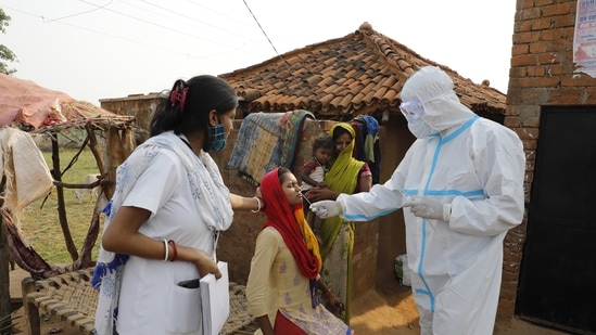 Health workers taking a nasal swab from a woman to test for Covid-19 infection in Jamsoti village, Uttar Pradesh on June 8. In Jamsoti, a village tucked deep inside India’s most populous state of Uttar Pradesh, the common refrain among the villagers is that the coronavirus spreads only in cities. The deadly infection, they believe, does not exist in villages, AP reported.(Rajesh Kumar Singh / AP)