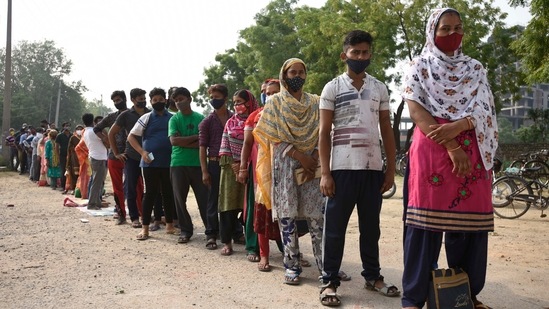 Domestic help and daily wage workers in a long queue outside a vaccination centre at Government Middle school, in Fajilpur Jharsha, Gurugram on June 21. Until June 21, close to 300 million vaccine doses had been administered across the country since the national Covid-19 immunisation drive began in the country on January 16.(Parveen Kumar / HT Photo)