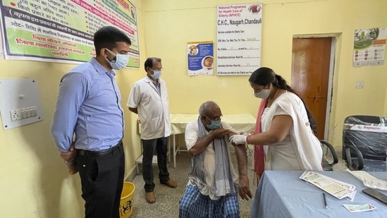 District magistrate Sanjeev Singh (L) overlooks a health worker administering a vaccine to a villager at Naugarh, in Chandauli district, Uttar Pradesh on June 10. Prime Minister Narendra Modi and other leaders have routinely spoken about the need to shun vaccine hesitancy, but health experts say more needs to be done.(Rajesh Kumar Singh / AP)